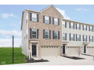 Charming brick front exterior of townhome with attached garage and well-manicured lawn at 7282 Zanesville Rd, Carmel, IN 46033