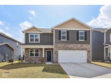 Two-story home featuring stone accents, a two-car garage, and well-maintained landscaping at 8131 Trailstay Dr, Camby, IN 46113
