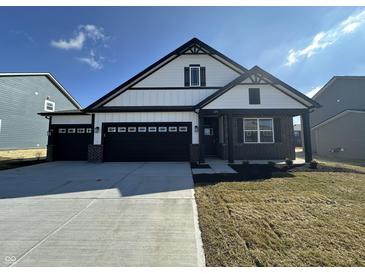 Charming home showcasing a black three-car garage, white siding, and brick accents for an inviting curb appeal at 273 Lar Lan Dr, Danville, IN 46122