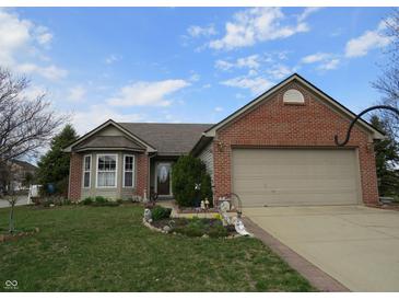 Charming single-story home with a well-maintained lawn and a two-car garage showcasing curb appeal at 744 Helm Dr, Avon, IN 46123