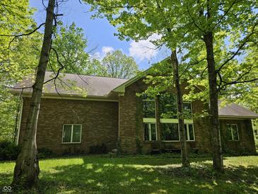 A lovely brick house boasts large windows and lush trees on a sunny day at 4257 Tattersall Dr, Plainfield, IN 46168