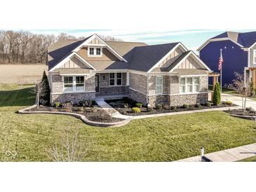 Attractive stone and shingle exterior of a charming ranch home with a manicured lawn at 12535 Tidecrest Dr, Fishers, IN 46037