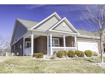 Charming brick home featuring a cozy covered porch with white railings and a well-manicured lawn at 4326 Switchgrass Way, Indianapolis, IN 46237