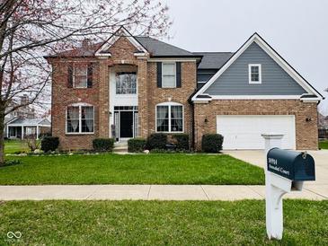Traditional brick home with a manicured lawn, attached garage, and mature landscaping at 14914 Annabel Ct, Westfield, IN 46074