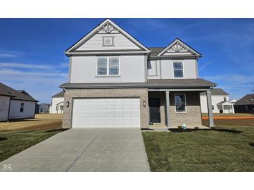 Two-story home featuring gray siding, brick facade, two-car garage, and a well-manicured front lawn at 6196 Granby Dr, Whitestown, IN 46075