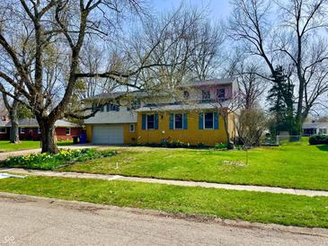 Charming two-story home with a well-manicured lawn and beautiful flowers at 927 Stockton St, Indianapolis, IN 46260