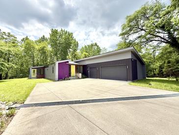 Modern home with a large driveway, two-car garage, and unique color accents at 7650 Clarion Dr, Indianapolis, IN 46236