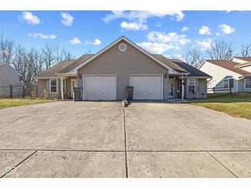 Tan duplex with two-car garages and a shared driveway at 3858 Fetlock Dr, Indianapolis, IN 46227