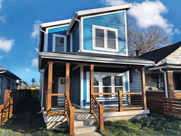 Stunning two-story blue home with a modern design, wooden porch, and landscaped lawn at 3271 Winthrop Ave, Indianapolis, IN 46205