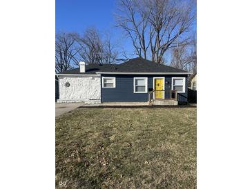 Charming ranch home with a blue exterior, white stone accents, and a yellow front door at 3712 N Bancroft St, Indianapolis, IN 46218