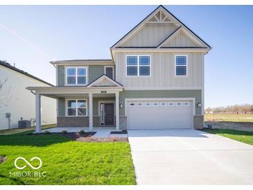 Charming two-story home featuring a two-car garage and covered porch at 1585 Hanover St, Danville, IN 46122