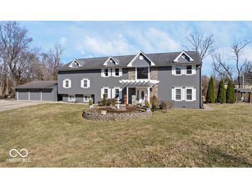 Charming two-story home featuring gray siding, white trim, and a beautifully landscaped front yard at 2227 Hidden Orchard Ct, Indianapolis, IN 46228