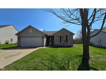 Charming single-story home features a brick facade, attached garage, and well-maintained lawn on a sunny day at 6024 Boulder Dr, Anderson, IN 46013