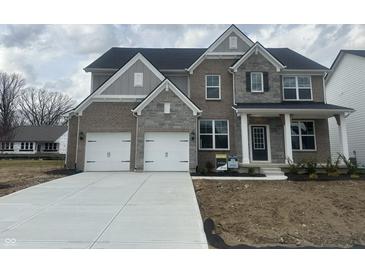 Charming two-story home featuring a mix of brick and stone, a two-car garage, and a welcoming front porch at 4958 Reavie Ct, Noblesville, IN 46062
