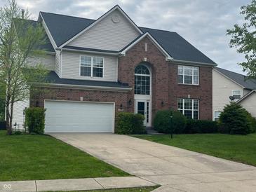 Traditional two-story home featuring a brick facade, an attached two-car garage, and a well-maintained lawn at 13271 Lorenzo Blvd, Carmel, IN 46074