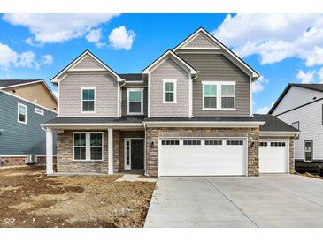 Charming two-story home featuring stone accents, a two-car garage, and a well-manicured lawn on a sunny day at 20397 Hudson Bay Ln, Westfield, IN 46074