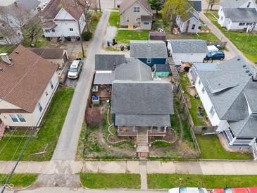 An aerial view captures the blue house in its neighborhood, showcasing yard, garage, and the community at 323 E Franklin St, Shelbyville, IN 46176
