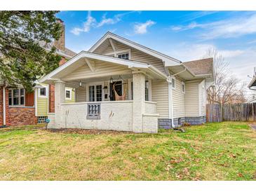 Charming bungalow with covered front porch, white brick foundation, and inviting curb appeal at 610 N Drexel Ave, Indianapolis, IN 46201