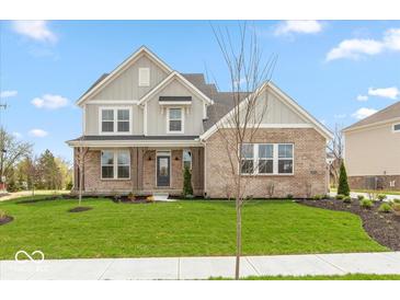 Charming two-story home with brick and siding exterior and beautifully landscaped front yard at 6973 Oakdale Ln, Avon, IN 46123