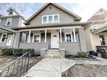 Charming two-story home with a welcoming front porch and gray painted brick and siding at 1715 Union St, Indianapolis, IN 46225