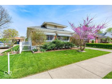 Charming home with well-maintained lawn, white picket fence, and blooming tree at 1641 Winton Ave, Indianapolis, IN 46224