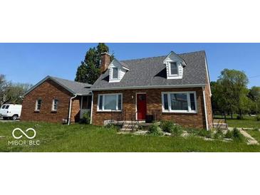 Charming brick home featuring a red door and dormer windows under a gray roof at 3192 E Main St, Plainfield, IN 46168