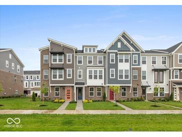 Charming townhomes with colorful doors and well-maintained lawns in a friendly neighborhood setting at 7340 W County Road 600 Rd, McCordsville, IN 46055