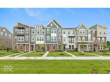 Beautiful townhomes featuring varied colors, brick accents, and professionally landscaped yards with sidewalks and green grass at 7344 W County Road 600, McCordsville, IN 46055