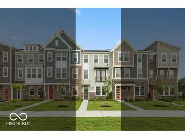 View of new townhomes showcasing brick and siding exteriors, complemented by well-maintained lawns and inviting walkways at 7348 W County Road 600 Rd # 12-604, McCordsville, IN 46055