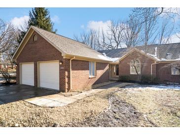 Brick ranch home with attached two-car garage and landscaped yard at 9110 W Point Dr, Indianapolis, IN 46268