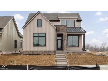 Charming two-story home with brick accents, light brown siding and steps leading to a covered front porch at 17368 Pinellas Ave, Westfield, IN 46074