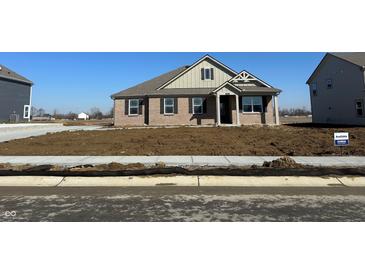 Charming single-story brick home featuring a covered front porch and a well-manicured lawn at 7840 Magnolia St, New Palestine, IN 46163