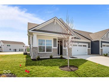 Charming single-story home boasts stone accents, gray siding, and a two-car garage with a well-manicured lawn at 16892 Cattle Hollow Ln, Noblesville, IN 46060