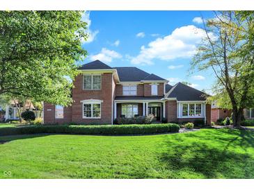 Beautiful brick home features manicured lawn and mature trees, creating a welcoming curb appeal at 3441 S Overlook Pass, New Palestine, IN 46163