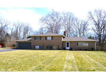 Charming brick home featuring a well-maintained lawn and mature trees in a desirable neighborhood at 7027 Creekside Ln, Indianapolis, IN 46220
