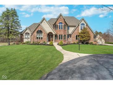 Stunning brick home with a well-manicured lawn, mature trees, and a circular driveway at 3592 W Smokey Row Rd, Bargersville, IN 46106