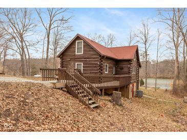 Charming log cabin with a spacious deck, nestled in a wooded setting with lake access at 7987 N Lasalle Rd, Morgantown, IN 46160