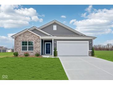 Charming single-story home featuring a brick and vinyl facade, well-manicured lawn, and an attached two-car garage at 113 Luna Pl, Shelbyville, IN 46176