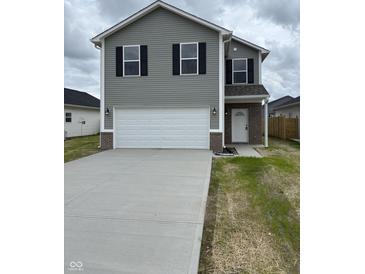 Charming two-story home with a gray exterior, white garage door, and well-maintained lawn at 1433 Wigwam Ln, Martinsville, IN 46151
