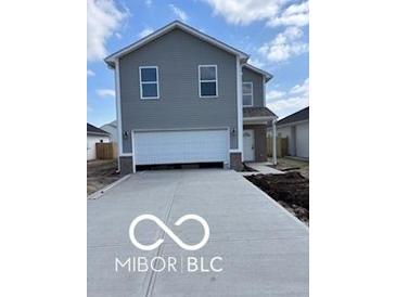 Charming two-story home with gray siding, a wide driveway, and a spacious two-car garage at 1433 Wigwam Ln, Martinsville, IN 46151