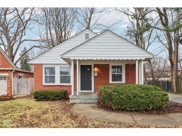 Brick ranch house with white trim, covered porch, and landscaped yard at 2314 E 58Th St, Indianapolis, IN 46220