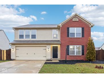 Two-story brick and beige home with a two-car garage and landscaped lawn at 7988 Kersey Dr, Indianapolis, IN 46236