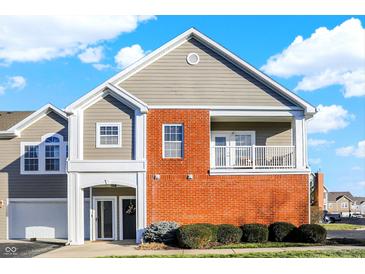 Two-story townhome with brick and siding exterior, attached garage, and balcony at 9774 Herring Gull Dr, Carmel, IN 46280