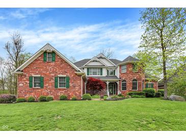 Inviting two-story brick home with manicured lawn, lush landscaping, and traditional architectural details at 1398 Penny Ln, Greenfield, IN 46140