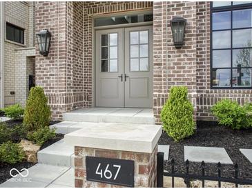 Inviting brick home featuring a stylish front door and well-manicured landscaping at 467 Rayle Dr, Carmel, IN 46032