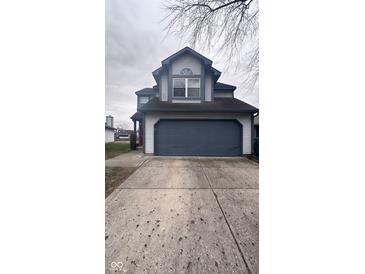 Two-story house with a gray and white exterior, attached garage, and a red front door at 4059 Eagle Cove W W Dr, Indianapolis, IN 46254