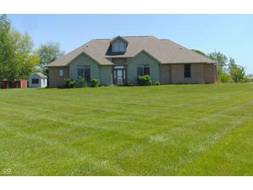 Charming brick home boasts a well-manicured lawn, creating a welcoming curb appeal at 7099 S 1100 W, Jamestown, IN 46147