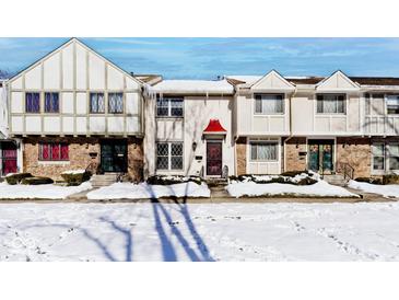 Snow covered townhouses with red awnings and brick fronts at 8021 E 20Th St, Indianapolis, IN 46219