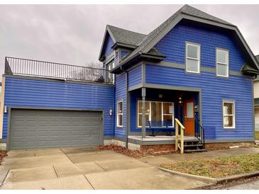 Stunning blue two-story home with gray accents, a detached garage, and a deck at 114 N Oriental St, Indianapolis, IN 46202