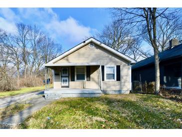 Tan house with a front porch, and a small yard at 1338 W 25Th St, Indianapolis, IN 46208